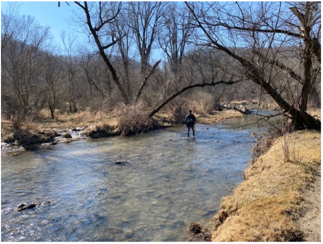 Sean standing in a stream