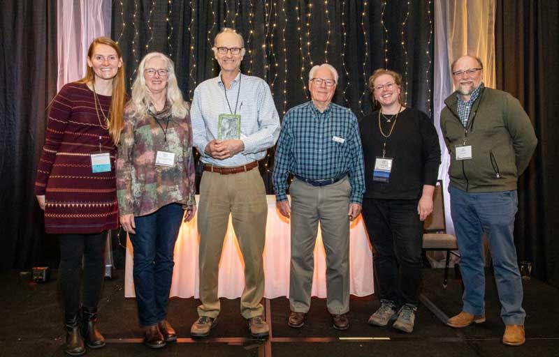 A small group of award winners standing on a stage