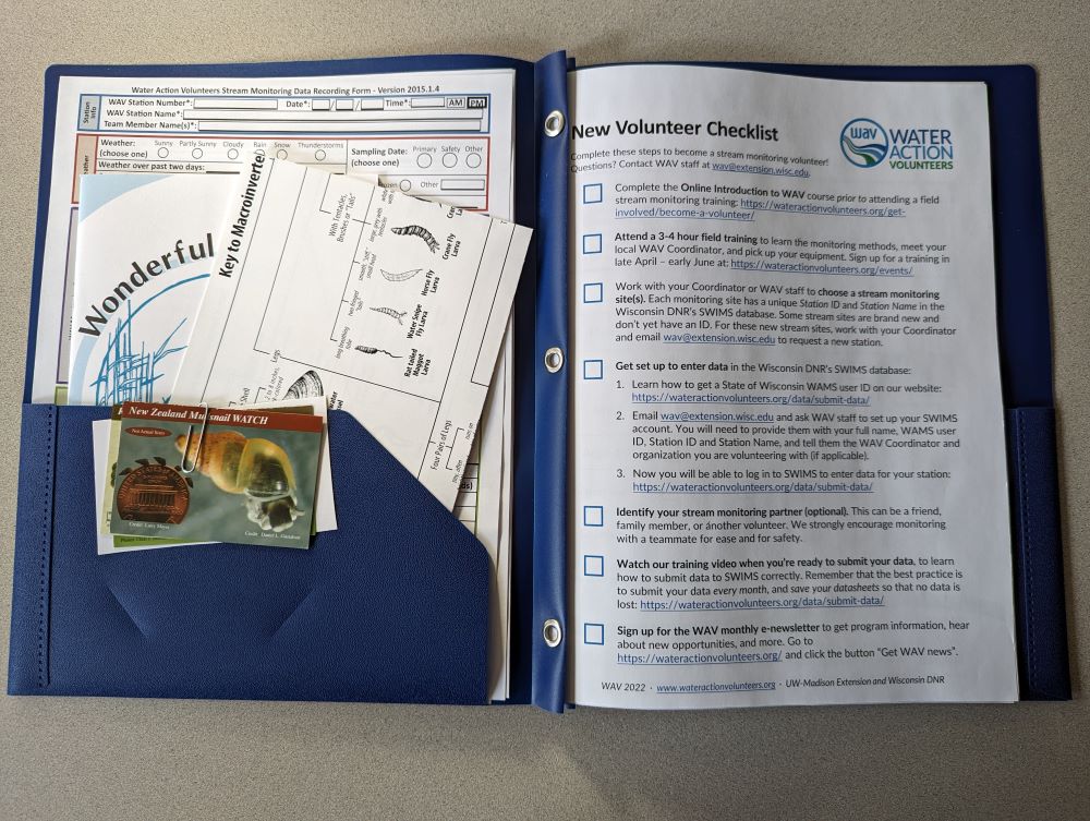 A Welcome Packet sits open on a table, with materials displayed inside.