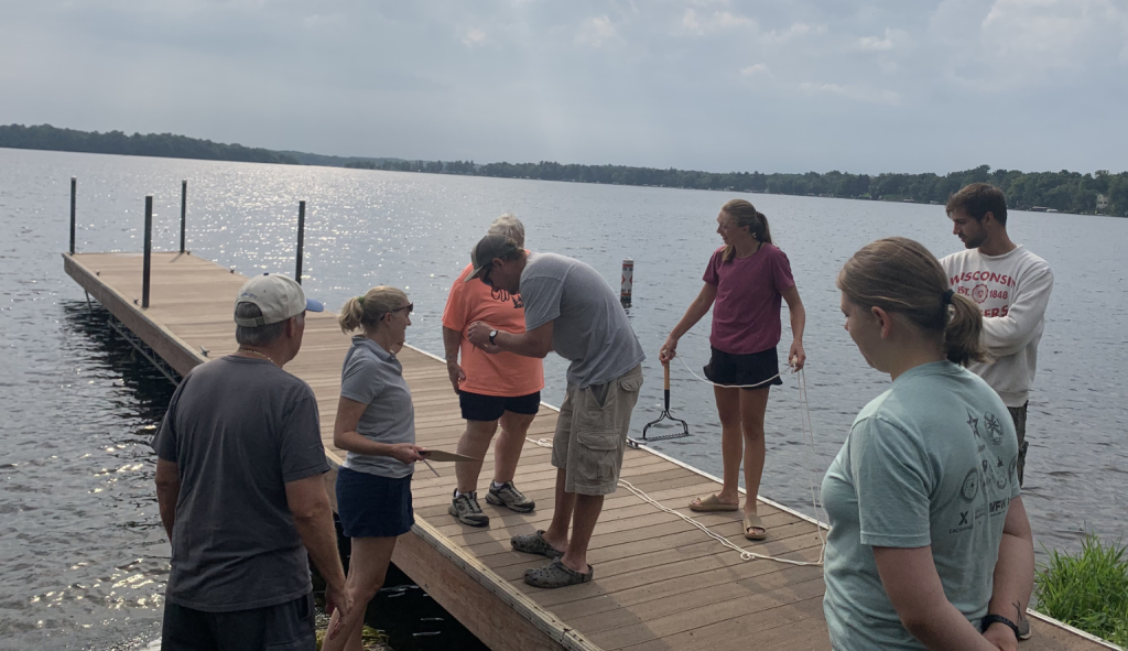 A group of volunteers stand on a dock on an overcast day. 