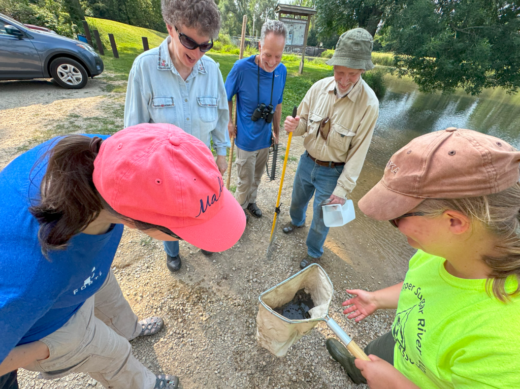 A group of volunteer stand around a net. 