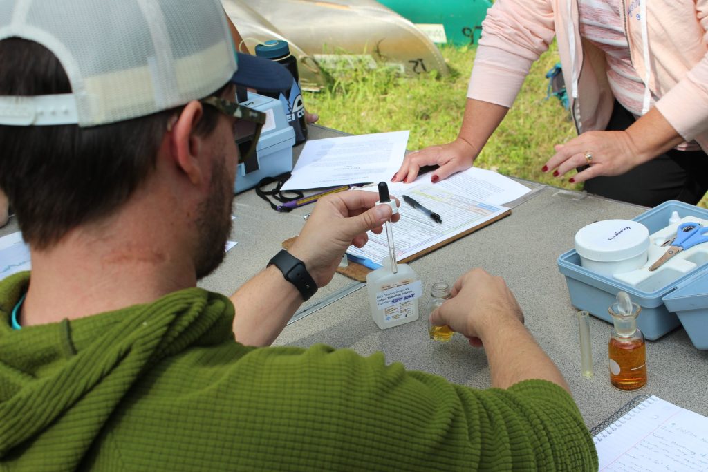A man tests dissolved oxygen of a prepared sample by using a dropper bottle to titrate.
