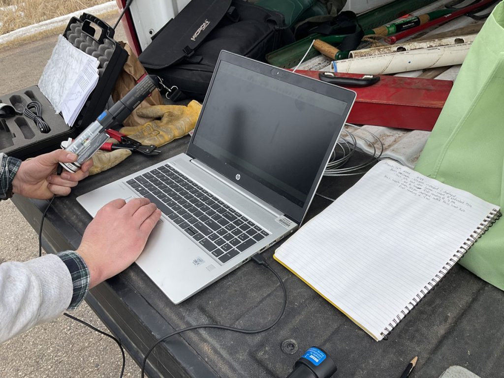 A person loading thermistor data onto a laptop.