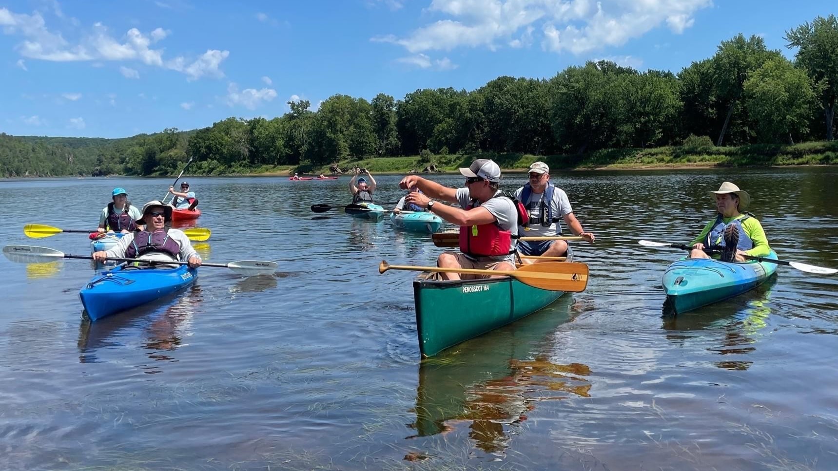An instructor leads a group paddle, searching for aquatic invasive species.